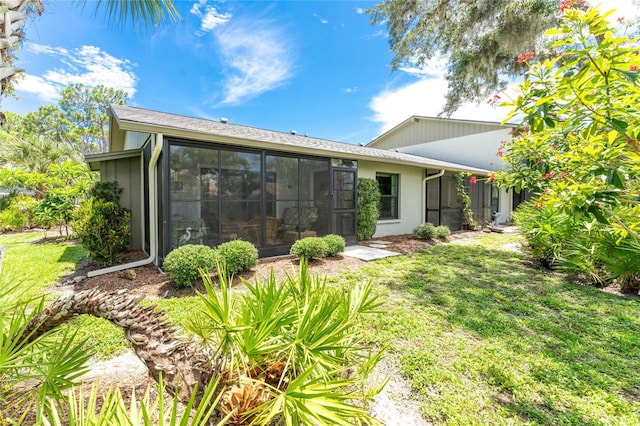 back of property featuring a sunroom and a yard