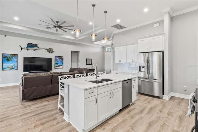 kitchen featuring a kitchen island with sink, sink, white cabinets, and appliances with stainless steel finishes