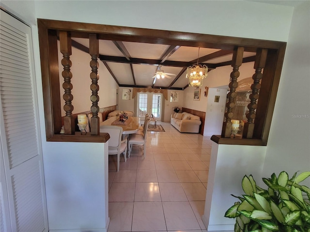 interior space featuring ceiling fan with notable chandelier, light tile patterned floors, and vaulted ceiling with beams