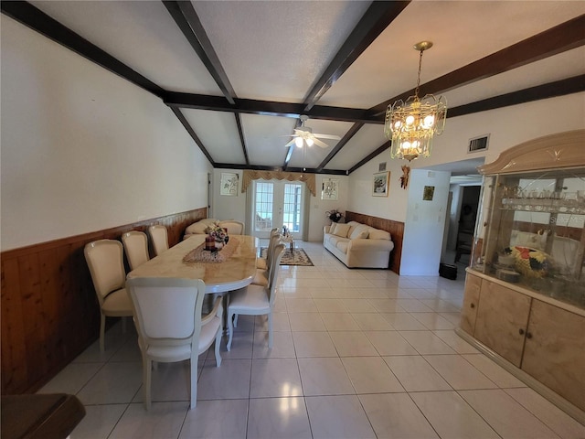 dining area featuring light tile patterned floors, wooden walls, vaulted ceiling with beams, a textured ceiling, and ceiling fan with notable chandelier