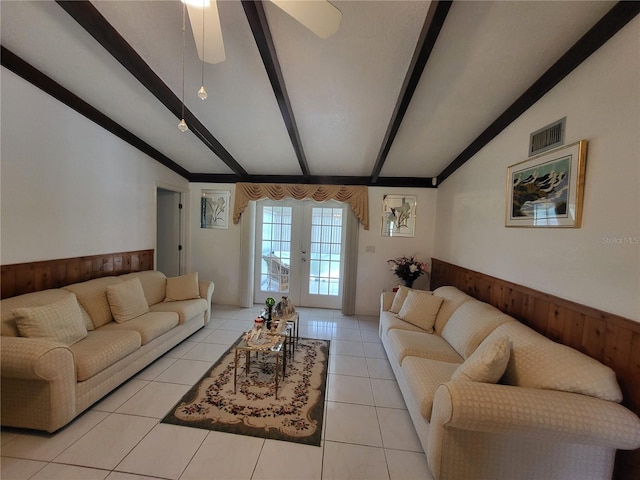 living room featuring ceiling fan, wood walls, vaulted ceiling with beams, light tile patterned floors, and french doors