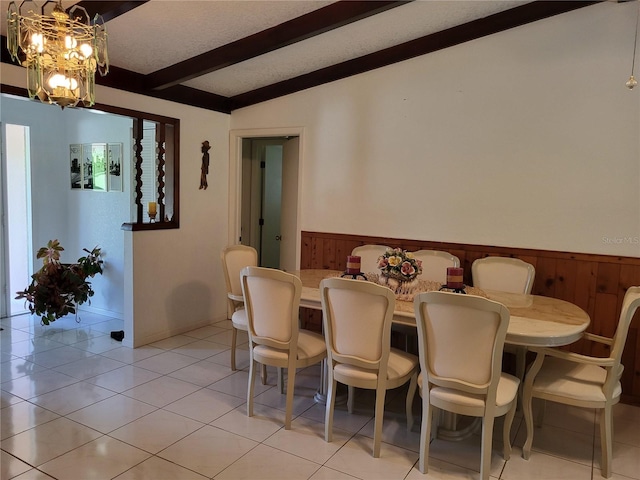 dining room with light tile patterned floors, wood walls, a chandelier, and lofted ceiling with beams