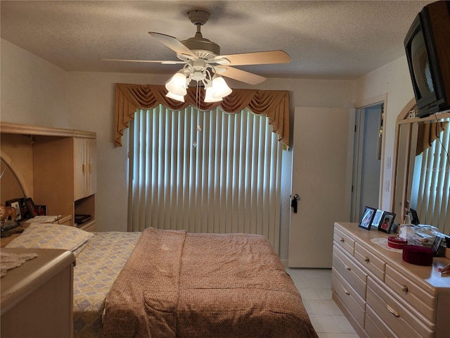 bedroom with a textured ceiling, ceiling fan, and multiple windows