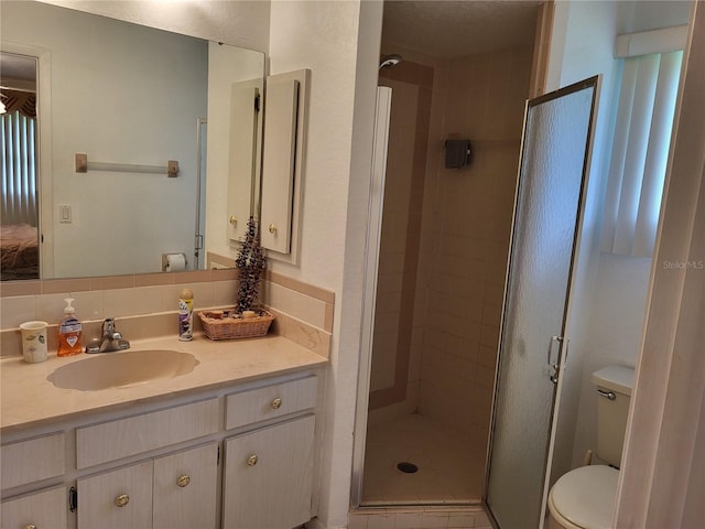 bathroom with toilet, vanity, an enclosed shower, and tasteful backsplash