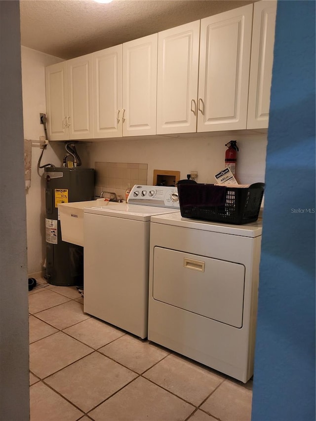 laundry room featuring water heater, light tile patterned floors, washer and clothes dryer, and sink