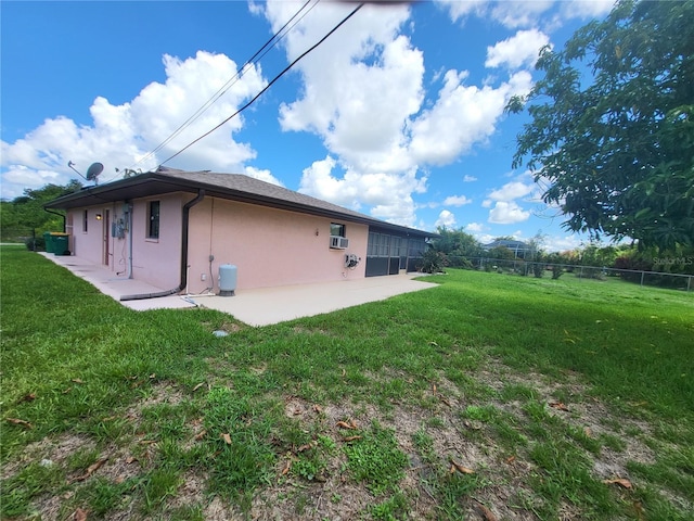 view of side of home featuring a patio area and a lawn