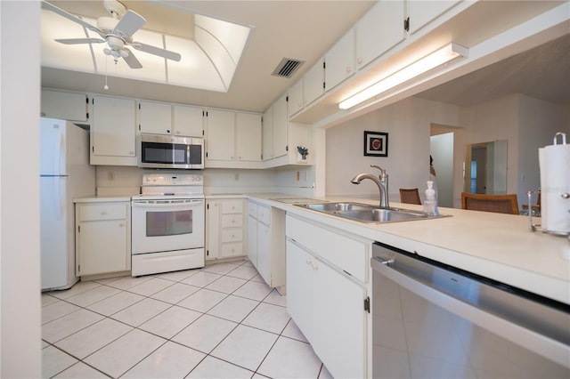 kitchen featuring white cabinets, stainless steel appliances, light tile patterned flooring, and sink