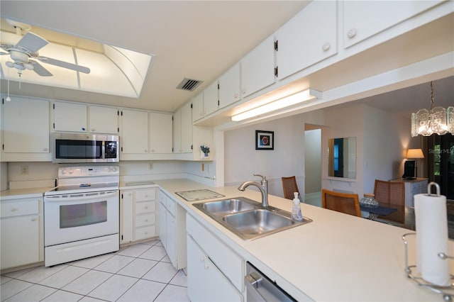 kitchen with ceiling fan with notable chandelier, sink, decorative light fixtures, white cabinetry, and stainless steel appliances