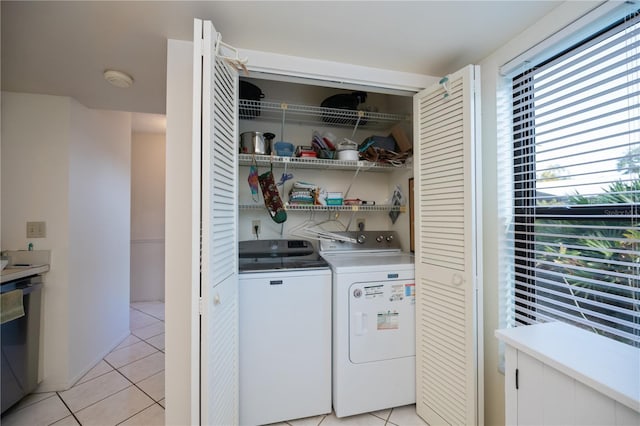 clothes washing area with light tile patterned floors and independent washer and dryer