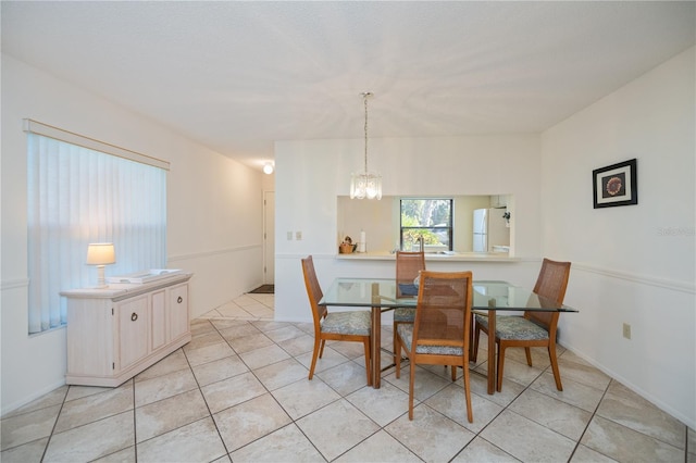 dining space featuring light tile patterned floors and an inviting chandelier