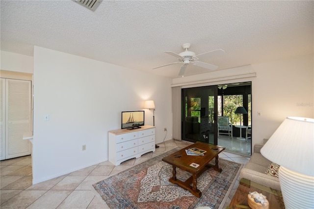 tiled living room featuring ceiling fan and a textured ceiling