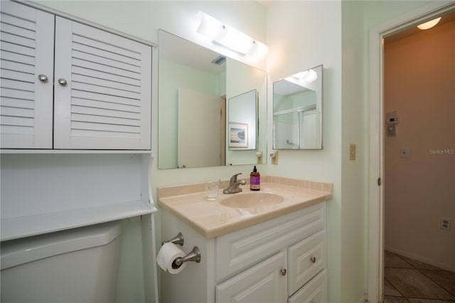 bathroom featuring tile patterned flooring, vanity, and toilet