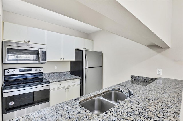 kitchen with white cabinets, sink, stone counters, and stainless steel appliances