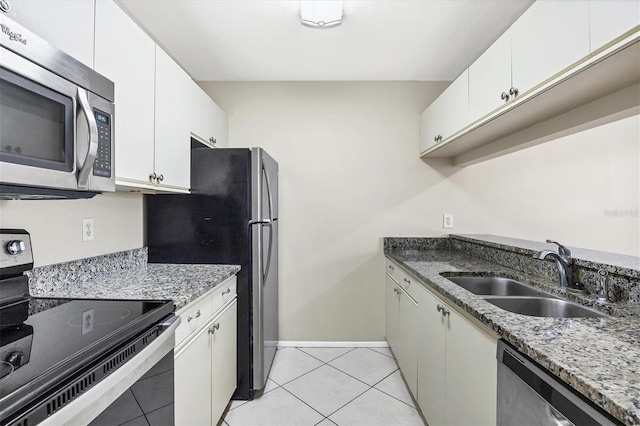 kitchen with light tile patterned floors, sink, white cabinetry, and appliances with stainless steel finishes