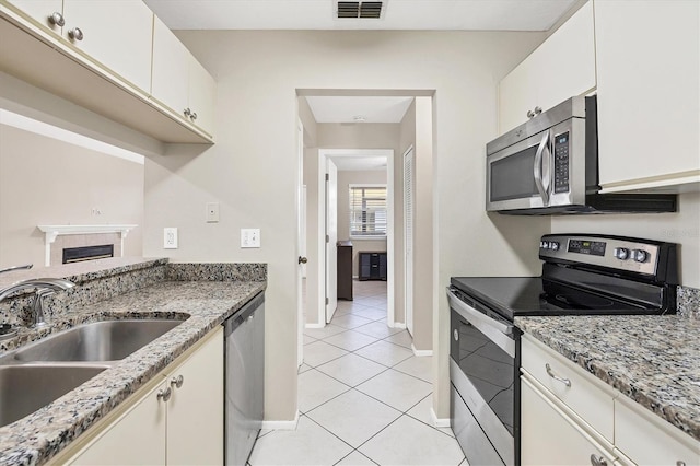 kitchen featuring light stone counters, sink, white cabinets, and appliances with stainless steel finishes