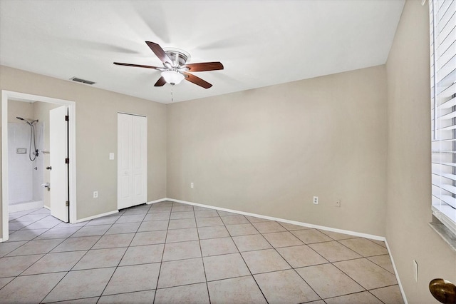 unfurnished bedroom with ceiling fan, light tile patterned floors, and a closet