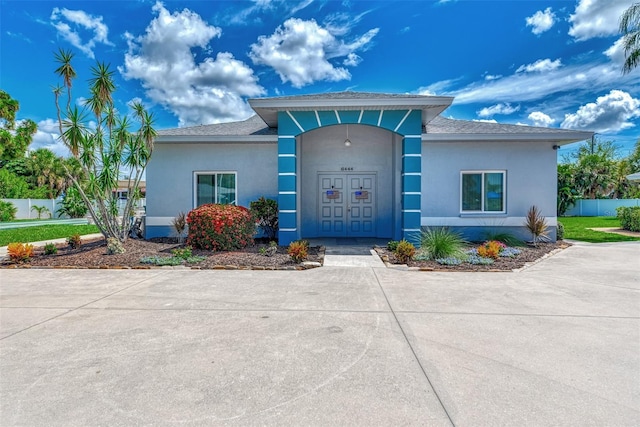 view of front of house with stucco siding and fence