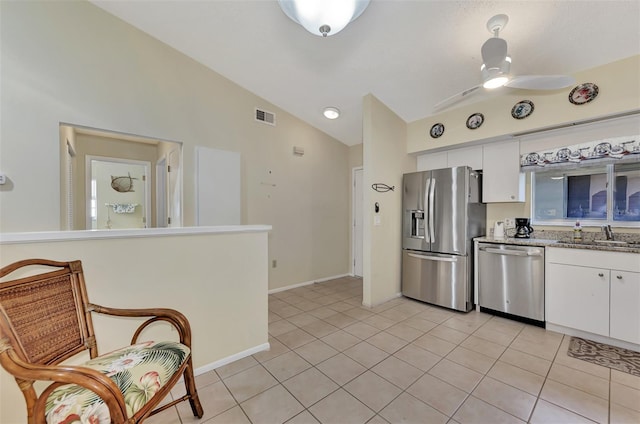 kitchen featuring light tile patterned flooring, ceiling fan, stainless steel appliances, white cabinets, and lofted ceiling