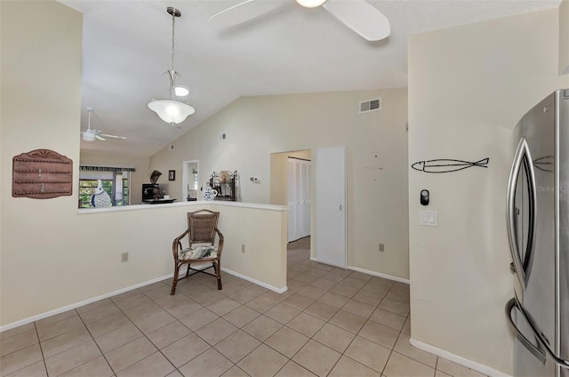 kitchen featuring light tile patterned flooring, lofted ceiling, ceiling fan, stainless steel fridge, and decorative light fixtures