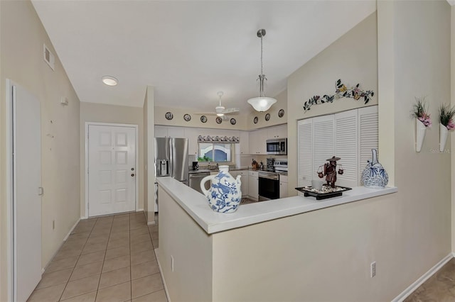 kitchen with light tile patterned flooring, white cabinetry, ceiling fan, stainless steel appliances, and hanging light fixtures