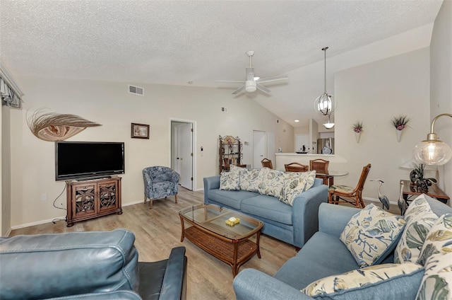 living room featuring high vaulted ceiling, a textured ceiling, ceiling fan, and hardwood / wood-style floors