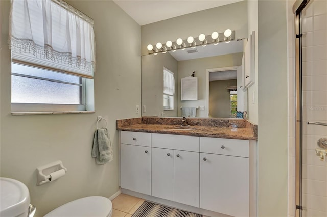 bathroom with tile patterned flooring, walk in shower, toilet, and vanity