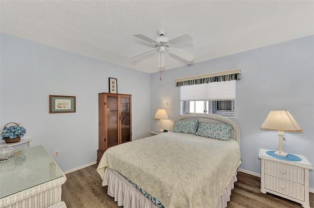 bedroom with a textured ceiling, ceiling fan, and dark hardwood / wood-style floors