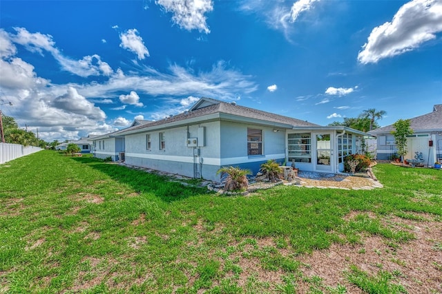 rear view of property with a lawn