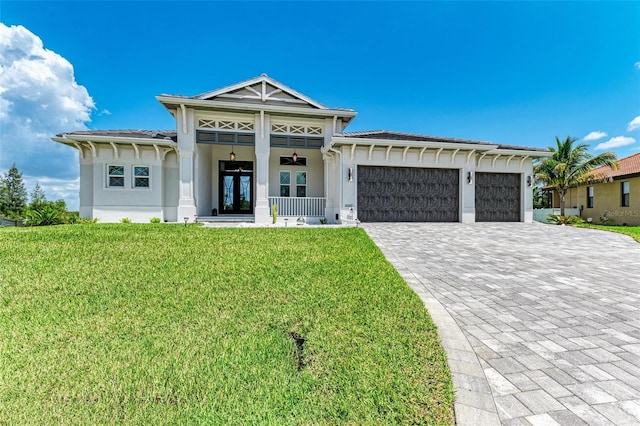 view of front of home with ceiling fan, french doors, a front yard, and a garage