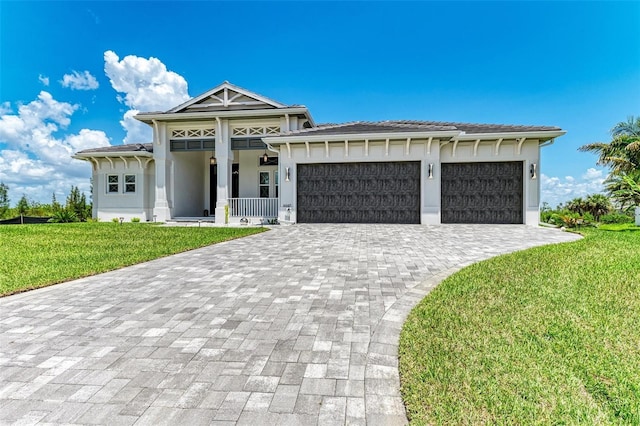 view of front of house with a front yard, a porch, and a garage