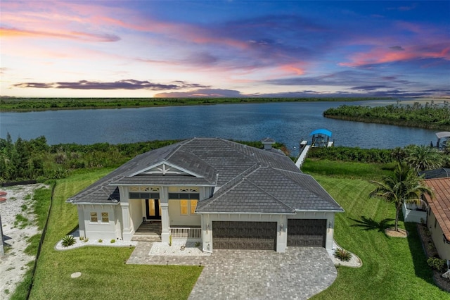 aerial view at dusk featuring a water view