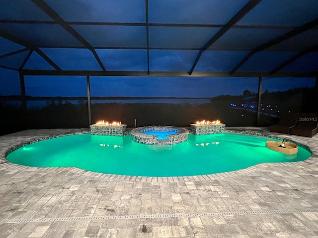 pool at twilight with a lanai and a patio