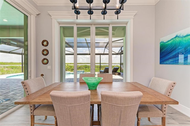 dining room with a wealth of natural light, crown molding, a chandelier, and hardwood / wood-style flooring