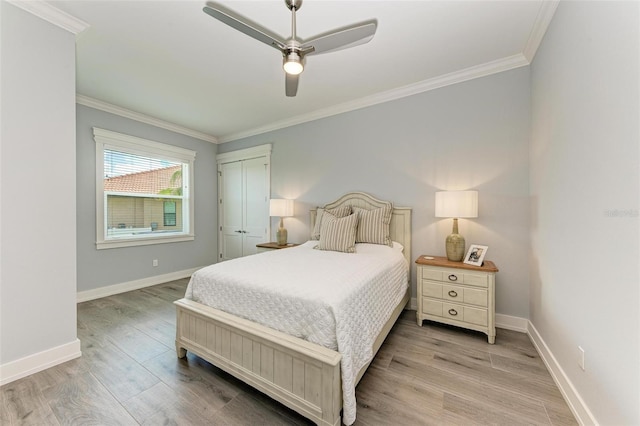 bedroom with ceiling fan, wood-type flooring, crown molding, and a closet