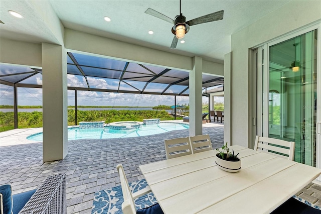 view of patio featuring a lanai, ceiling fan, and a pool with hot tub