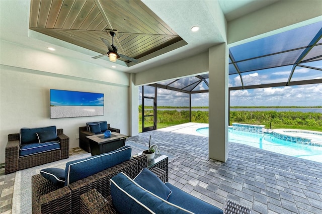 view of patio with outdoor lounge area, ceiling fan, and glass enclosure