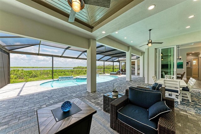 view of patio / terrace with outdoor lounge area, glass enclosure, ceiling fan, and a pool with hot tub