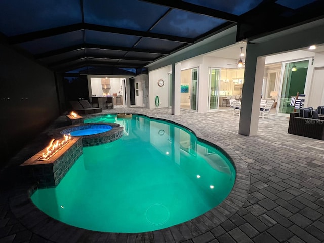 view of swimming pool with a lanai, a patio area, and an in ground hot tub