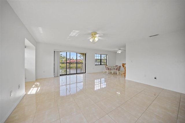 spare room featuring ceiling fan, a water view, and light tile patterned floors