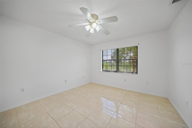 tiled empty room featuring ceiling fan