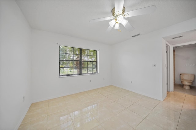 tiled empty room with ceiling fan