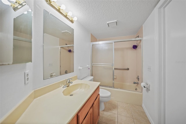 full bathroom with combined bath / shower with glass door, a textured ceiling, vanity, tile patterned flooring, and toilet