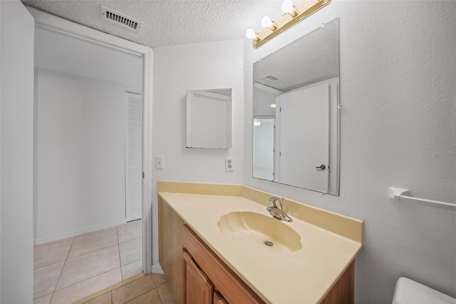 bathroom featuring tile patterned flooring, a textured ceiling, and vanity