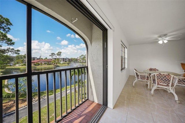 balcony with ceiling fan and a water view