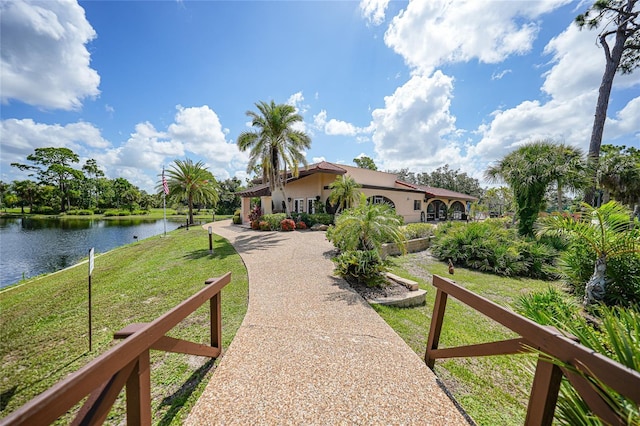 exterior space with a water view and a front lawn