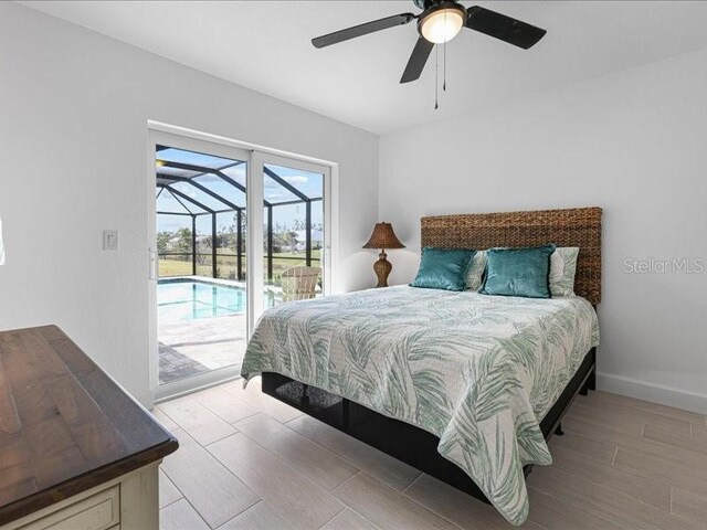 bedroom featuring access to exterior, a ceiling fan, a sunroom, wood finished floors, and baseboards