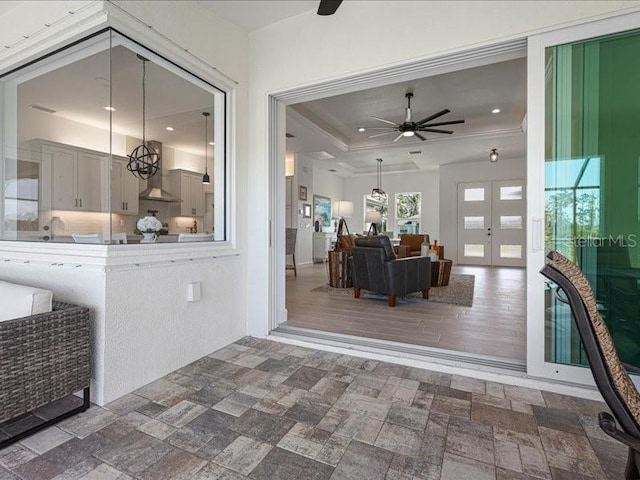 interior space featuring recessed lighting, a ceiling fan, french doors, stone finish flooring, and a tray ceiling