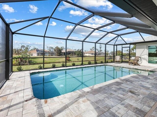 pool with glass enclosure and a patio