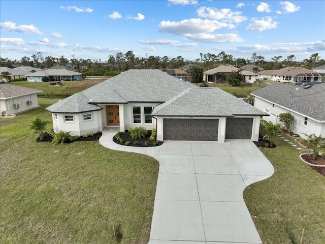 view of front of house with a garage, concrete driveway, a front lawn, and a shingled roof