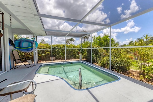 view of pool with a patio area and glass enclosure